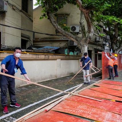 Workers dismantle barriers in a residential area in Shanghai on May 30 as the city prepares to open up. Photo: Reuters