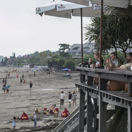 Tourists at a bar on Bali’s Batu Bolong Beach in Canggu, a once peaceful paradise known by few now overrun with hotels, resorts and restaurants. Photo: Getty Images