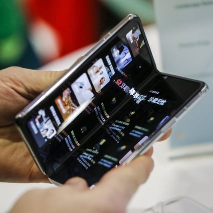 An attendee tries Oppo’s Find N foldable smartphone at a trade show in Barcelona in February 2022. Photo: Bloomberg