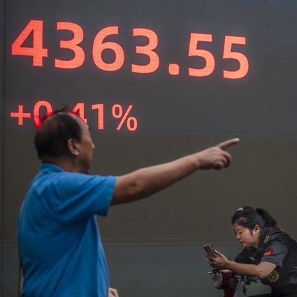 A man walks in front of the screen showing stock exchange and economic data in Shanghai, in October 2021. Photo: EPA-EFE