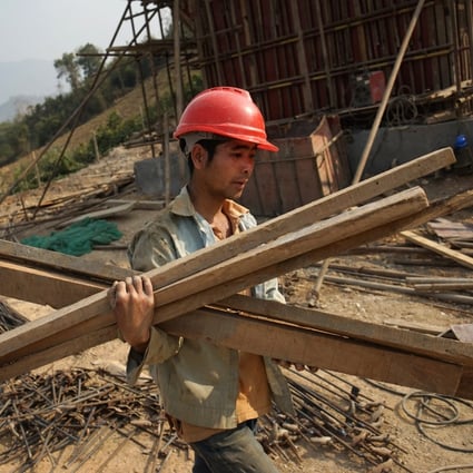 A Chinese worker in Luang Prabang carries materials for the China-Laos Railway, which opened in December. An influx of unskilled Chinese workers has fuelled tensions surrounding Southeast Asia’s belt and road projects. Photo: AFP