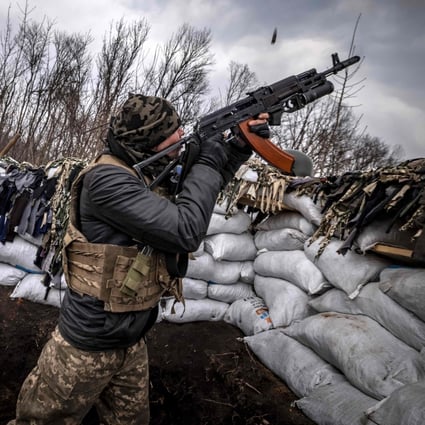 A Ukrainian serviceman shoots at a Russian drone with an assault rifle from a trench at the front line east of Kharkiv on March 31, 2022. Chinese military researchers predict drones armed with facial recognition and AI will be used in future conflicts. Photo: AFP