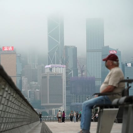 Fog hangs over the Hong Kong skyline as people gather on the Tsim Sha Tsui promenade on May 23. Photo: Felix Wong