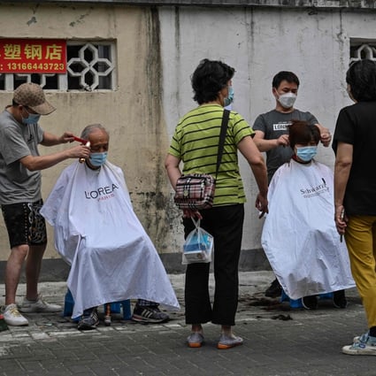 Residents received their haircuts out in the open on a street in the Jing’an district of Shanghai on June 3, 2022. Photo AFP