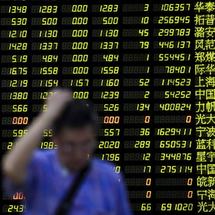 An investor stands in front of an electronic board showing stock information at a brokerage house in Shanghai. Photo: Reuters