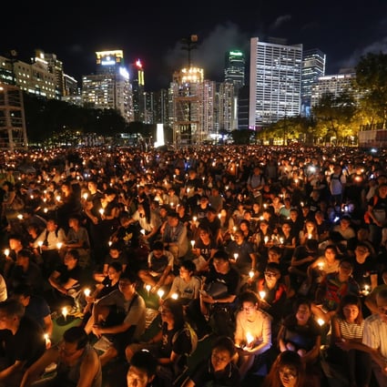 People hold up their candles during the June 4th Candle Light Vigil at Victoria Park in Causeway Bay. Photo: Dickson Lee