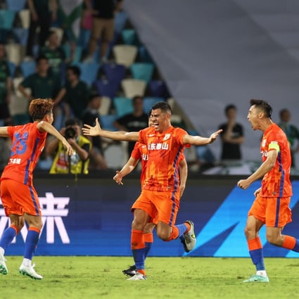 Shandong Taishan defender Jadson (centre) celebrates with teammates after scoring his side’s winner against Zhejiang in Haikou. Photo: Xinhua