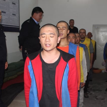 An undated image released by the Victims of Communism Memorial Foundation on May 24 shows detainees guarded by police as they recite or sing at the Tekes County Detention Centre in Xinjiang. Photo: AFP/Victims of Communism Memorial Foundation