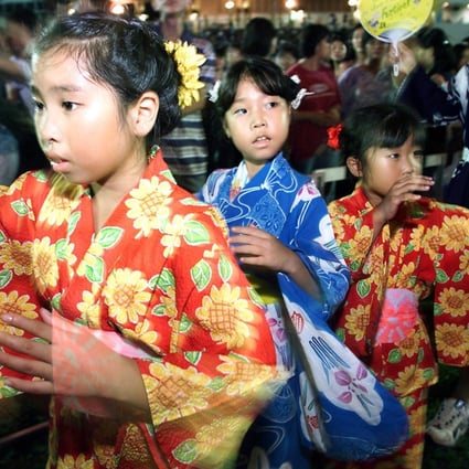 Young girls dressed in Japanese kimonos dance to music during a celebration of the Bon Odori festival in Kuala Lumpur in 1999. Photo: AFP