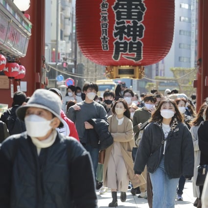 Japanese people wearing face masks to protect against the spread of the coronavirus walk through a shopping arcade in Tokyo. Photo: AP