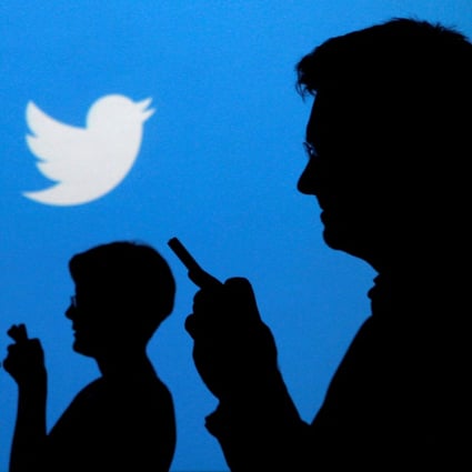 People holding mobile phones are silhouetted against a backdrop projected with the Twitter logo in this illustration picture taken in Warsaw on September 27, 2013. Photo: Reuters