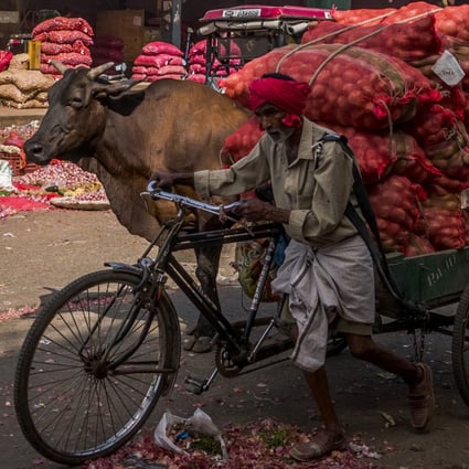 A worker pulls a cart full of vegetables and potatoes at the Azadpur wholesale market in New Delhi. Rising food and energy prices are further weakening the economic outlook in developing countries that were already under stress even before the Covid-19 pandemic. Photo: Bloomberg