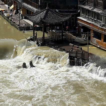 Flood waters sweep through the ancient town of Feng Huang in central China’s Hunan province. Photo: AP