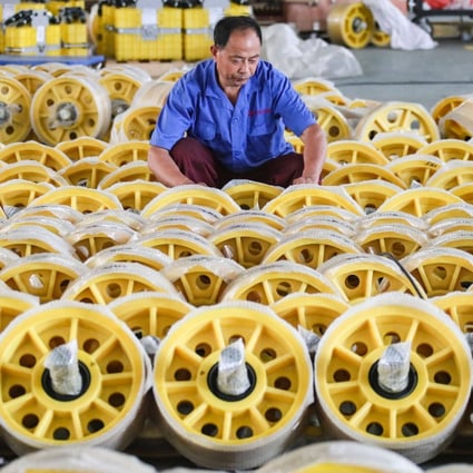 A worker adjusts the packaging on lift rollers at a factory in Huaian, in China’s eastern Jiangsu province, on June 9. Photo: AFP