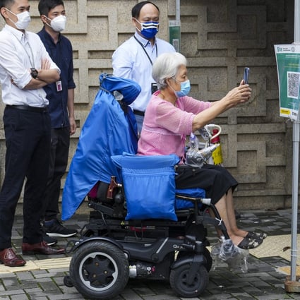 A person uses the Leave Home Safe app to enter the Ambulatory Care Centre at Queen Elizabeth Hospital in Jordan on June 13. Patients must now have a vaccine pass to  enter designated healthcare premises primarily providing non-urgent medical services. Photo: Sam Tsang