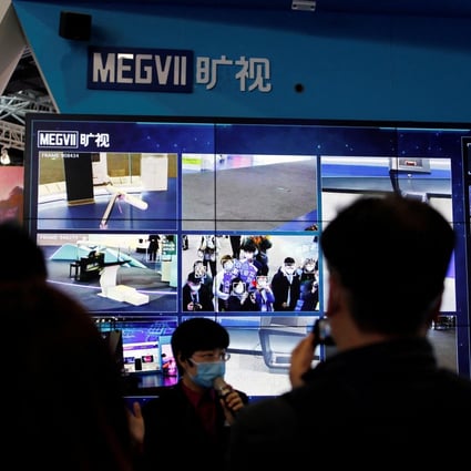 A staff member speaks in front of a display demonstrating the facial recognition system of Chinese artificial intelligence firm Megvii during an organised media tour at the Zhongguancun National Innovation Demonstration Zone Exhibition Center in Beijing on February 10, 2022. Photo: Reuters