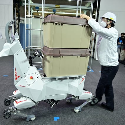 An employee of Japan’s Kawasaki Heavy Industries demonstrates a goat-like robot that can carry goods, in Tokyo, on March 9. By partnering with Microsoft for its industrial metaverse, the company plans to create a digital twin, or virtual replica, of its factories. Photo: Handout from Kawasaki Heavy Industries via Reuters  