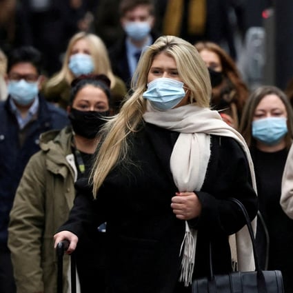 Commuters, most of them wearing face masks, walk along a platform at Kings Cross train station in London during morning rush hour in December. Photo: Reuters