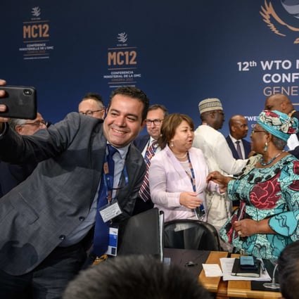 Delegates react with World Trade Organization Director General Ngozi Okonjo-Iweala (C) after the deals were reached. Photo: AFP