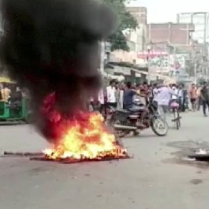 Demonstrators surround burning tyres on a street as they protest against “Agnipath scheme” for recruiting personnel for armed forces, in Jehanabad, Bihar, India on Thursday. Photo: ANI/Handout via Reuters