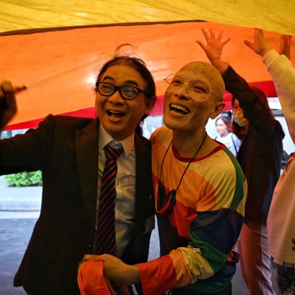 MP Thanyawat Kamolwongwat, left, celebrates with LGBT activists after the initial passing of the Move Forward Party’s marriage equality bill in Bangkok on Wednesday. Photo: AFP