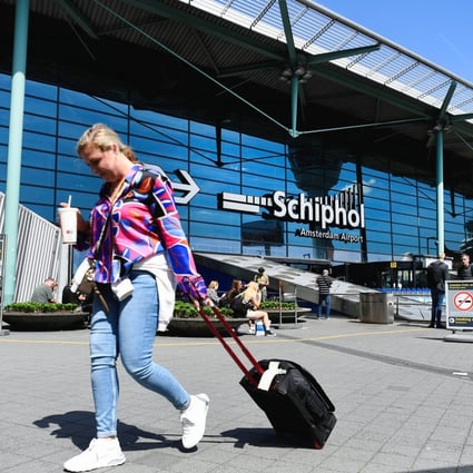 A woman with a suitcase walks outside Schiphol Airport in Amsterdam on Thursday. Photo: Reuters