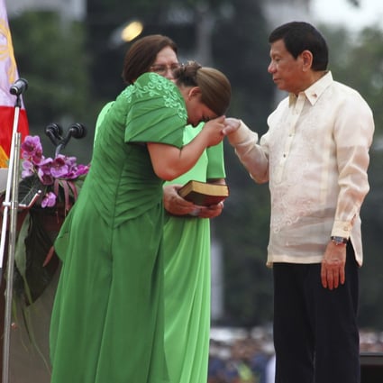Philippine Vice President-elect Sara Duterte places the hands of her father, outgoing Philippine President Rodrigo Duterte, on her forehead as a sign of respect during her early swearing in ceremony on Sunday. Photo: AP 