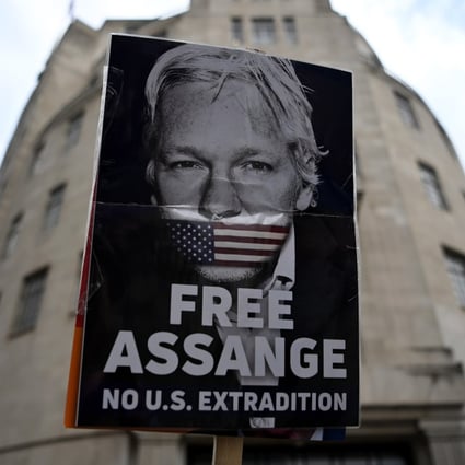 A protester holds up a placard demonstrating against Julian Assange’s extradition to the US in central London on Saturday. Photo: EPA-EFE