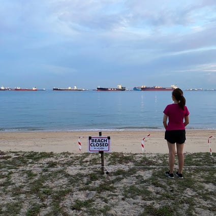 A woman looks at a closed public beach in Singapore in April 2020, during the Covid-19 pandemic. Photo: Reuters