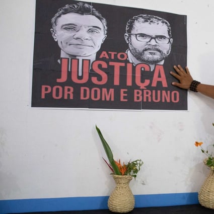 An indigenous woman touches a banner depicting the late indigenous expert Bruno Pereira and journalist Dom Phillips during a ceremony at the Union of Indigenous Peoples of the Javari Valley association’s headquarters in the municipality of Atalaia do Norte, state of Amazonas, Brazil, on June 21. Photo: AFP