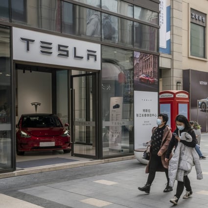 Shoppers walk past a Tesla showroom in Shanghai. China is considering extending the tax exemption on electric car purchases to help boost the Covid-hit sector. Photo: Bloomberg