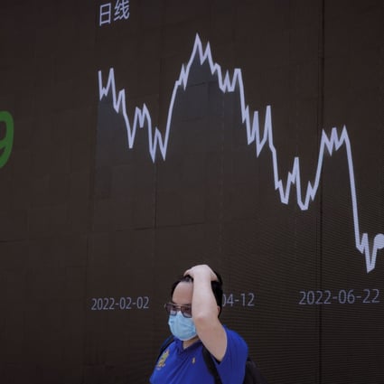 A man stands in front of a screen showing the latest economy and stock exchange updates in Shanghai on June 23, 2022. Photo: EPA-EFE