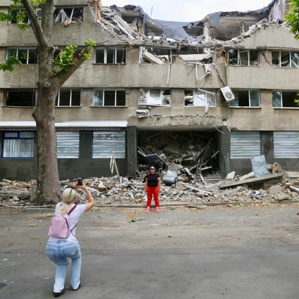 War tourists take photos outside a bombed out building in Mykolaiv, a city about 130km from Odesa, in Ukraine. Photo: Ian Neubauer