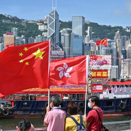 People wave Chinese and Hong Kong flags to mark the 25th anniversary of the handover of Hong Kong from Britain to China on June 28, 2022. Photo: AFP 