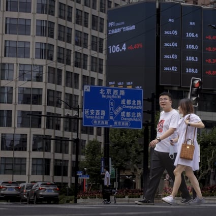 People walk in front of the jumbo screen showing the latest economic and stock updates in Shanghai on June 23. Photo: EPA-EFE