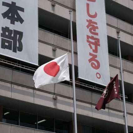 A Japanese national flag, left, and Liberal Democratic Party (LDP) flag fly at half-mast on Monday at the party’s headquarters in Tokyo. Photo: Bloomberg
