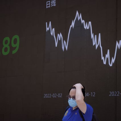 A man stands in front of the jumbo screen showing the latest economic and stock updates in Shanghai on June 23. Photo: EPA-EFE