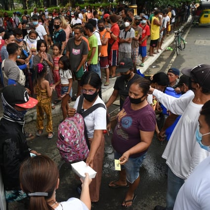 People queue for free meals in Manila last month, distributed by Catholic religious order Society of the Divine Word. Photo: AFP
