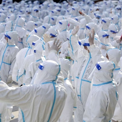 Medical workers who battled a Covid-19 outbreak  in Changchun, the capital of Jilin province, wave at residents during a farewell ceremony before leaving the city in early April. Photo: China Daily via Reuters