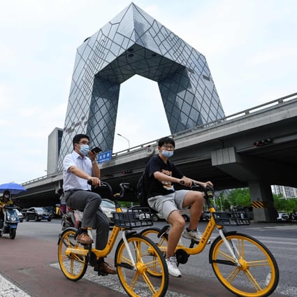 People ride along a street in Beijing’s central business district on July 8. Authorities have been dialling up policy support over the past few months. Photo: AFP