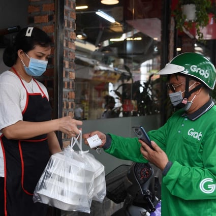 A Grab delivery worker picks up a food order from an eatery in Hanoi, Vietnam. File photo: AFP