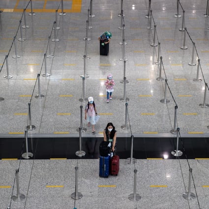 A woman and her children make their way to queue for a bus to their quarantine hotel in the arrival hall at Hong Kong International Airport on July 12. Photo: EPA-EFE