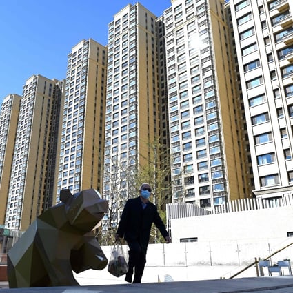 A man walks in front of a housing complex by China Evergrande in Beijing in October 2021. Photo: AFP