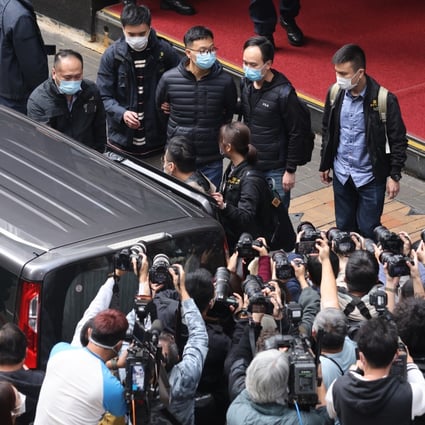 Stand News acting editor-in-chief Patrick Lam Shiu-tung being escorted to a waiting police vehicle after national security police raided his office on December 29, 2021. Photo: May Tse