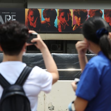 Fans of Canto-pop boy band Mirror take pictures of a billboard featuring the group outside Hong Kong Coliseum. Photo: Yik Yeung -man