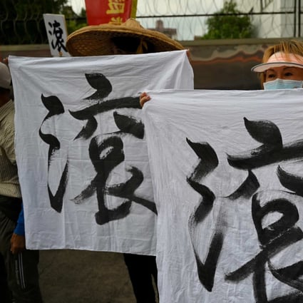 Pro-reunification activists display banners reading “Get out” as US House Speaker Nancy Pelosi visits Jing-Mei White Terror Memorial Park in New Taipei on August 3. Photo: AFP