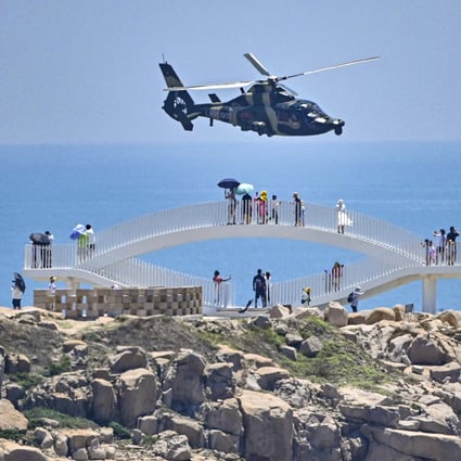 On Thursday, August 4, tourists watch a Chinese military helicopter fly past Pingtan Island, in Fujian province, ahead of massive military drills off Taiwan following US House Speaker Nancy Pelosi’s visit to the self-ruled island. Pingtan Island is one of mainland China’s closest points to Taiwan. Photo: AFP