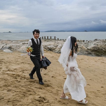 A couple prepare for a wedding photo shoot on the beach in Xiamen, with Taiwan’s Quemoy islands visible in the background. Photo: AFP