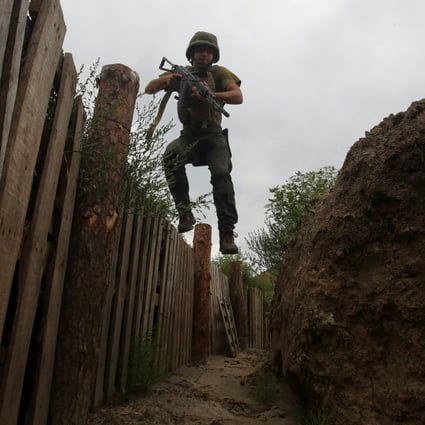 A member of the Ukrainian National Guard jumps into a trench at a position near a front line in Kharkiv region, Ukraine. Photo: Reuters