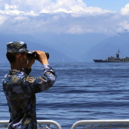 A People’s Liberation Army soldier looks on during military exercises in and over waters around Taiwan on August 5. A Taiwan frigate is seen in the background. Photo: Xinhua via AP